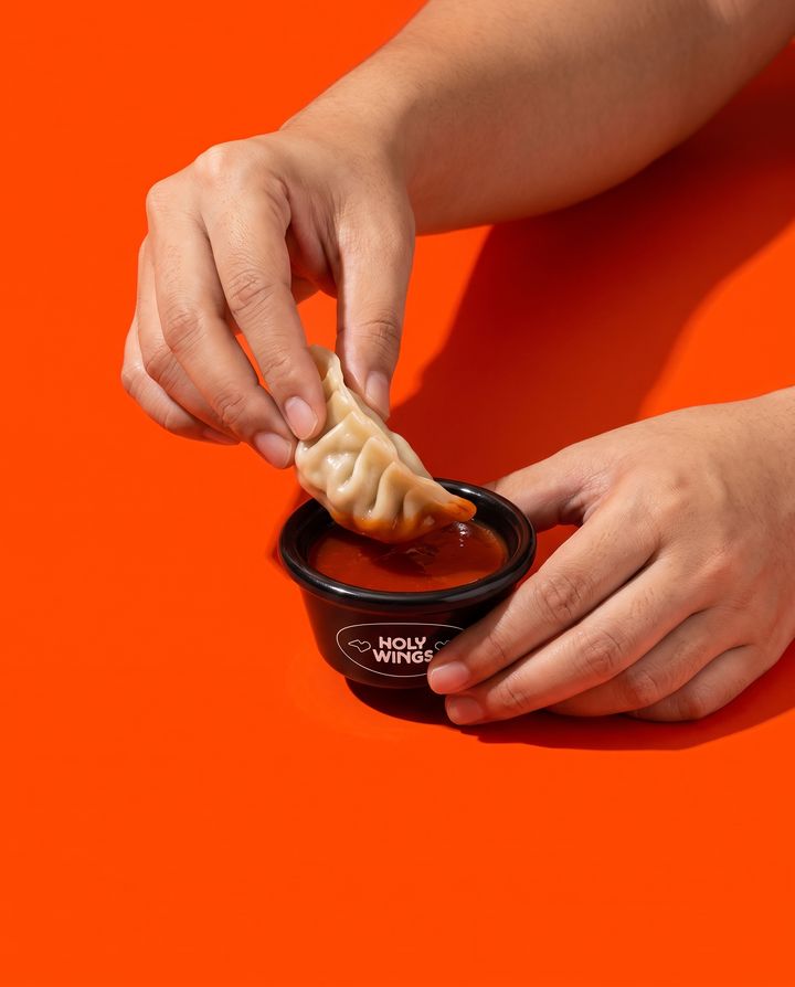 A dumpling dipped in red sauce
